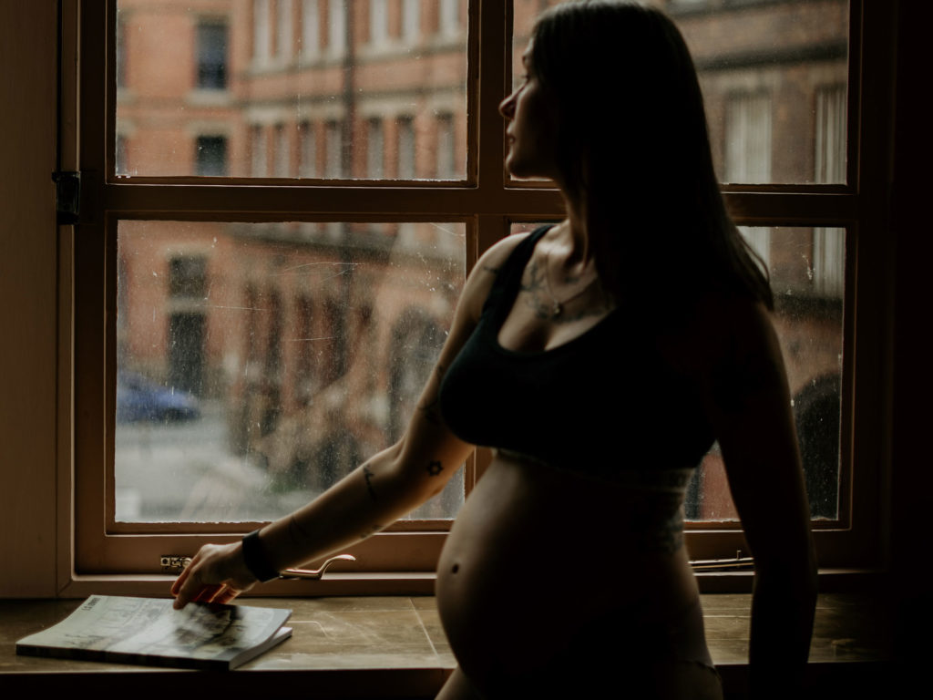 VIGEOVIT® Magnesium für Schwangerschaft. Schwangere Frau steht am Fenster.
